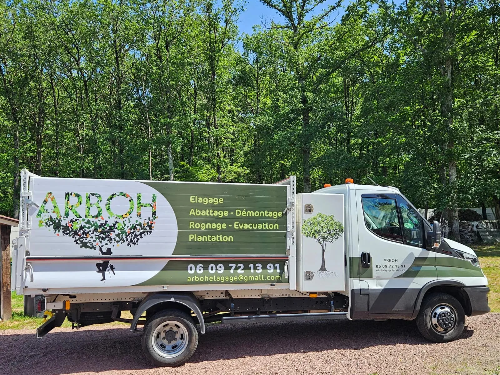 Camion ARBOH avec sa benne, garé en lisière de bois